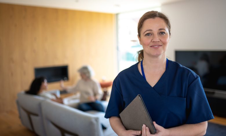 Portrait of nurse with a stethoscope at the patient's home. The Nurse looks at the camera