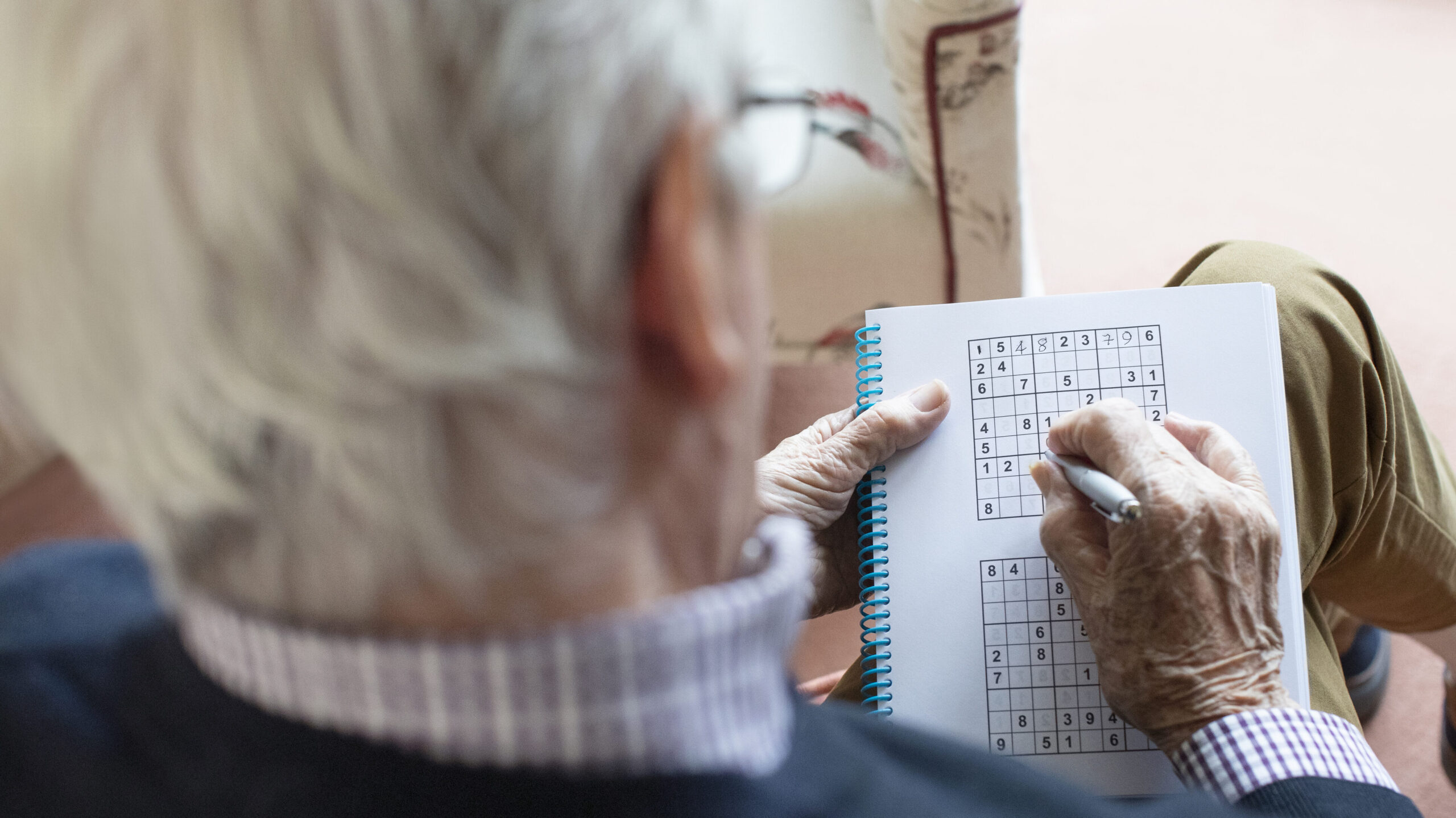 Senior Man Doing Sudoku Puzzle At Home
