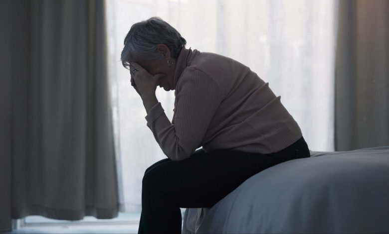 Stress, depression and sad old woman in bedroom with anxiety, mental health problem and debt in retirement. Lonely senior female person crying at home for headache, pain and fatigue of crisis in mind