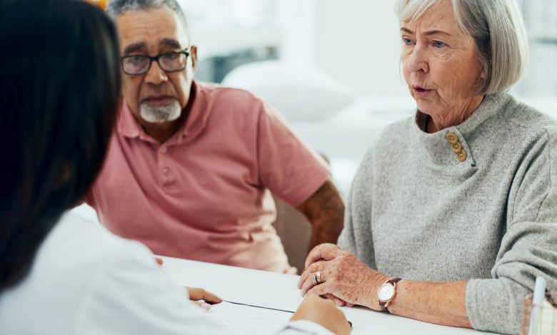 Doctor, consultation and discussion with elderly couple for insurance or healthcare policy at hospital. Medical employee, caregiver or nurse with senior patients for health prescription at clinic
