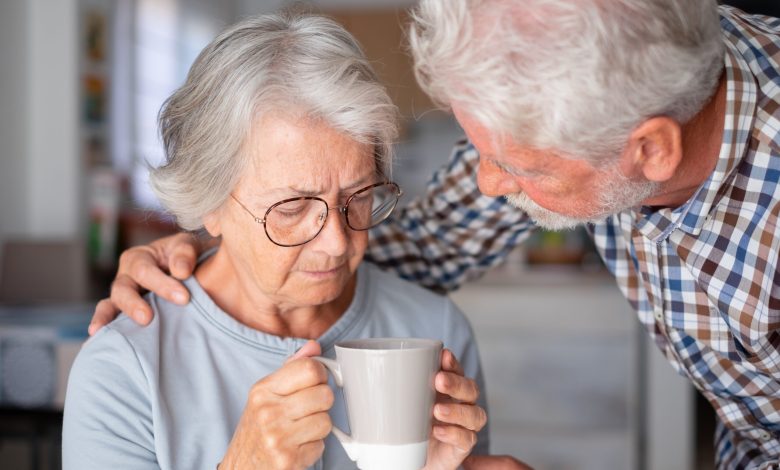 Old senior man comforting his depressed illness wife, unhappy elderly woman at home need medical help.