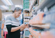 asian chinese senior man looking for medical supplies in drug store pharmacy shop