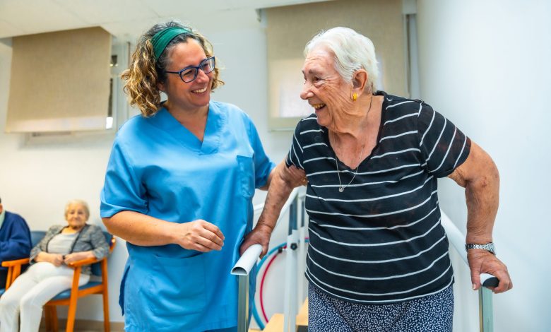 Senior patient doing physiotherapy at a geriatrics with help of a therapist walking on parallel bars