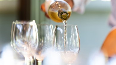 A waiter serves a glass of white wine
