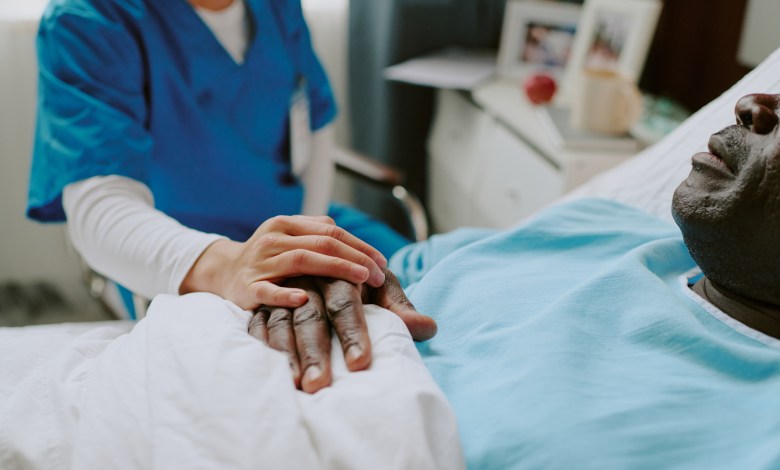 Nurse in scrubs holding hand of elderly patient. Scene portraying compassion, care, and medical support in a clinical setting, with healthcare services being rendered to a senior individual