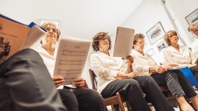 Senior Women Holding Music Sheets at Choir Practice.