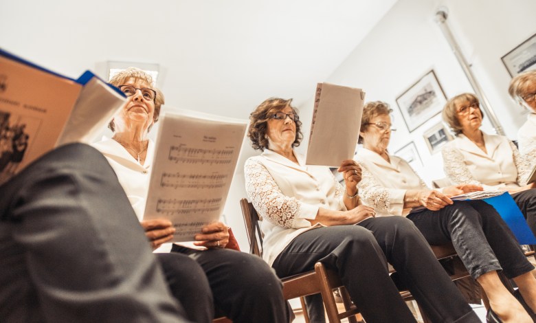 Senior Women Holding Music Sheets at Choir Practice.